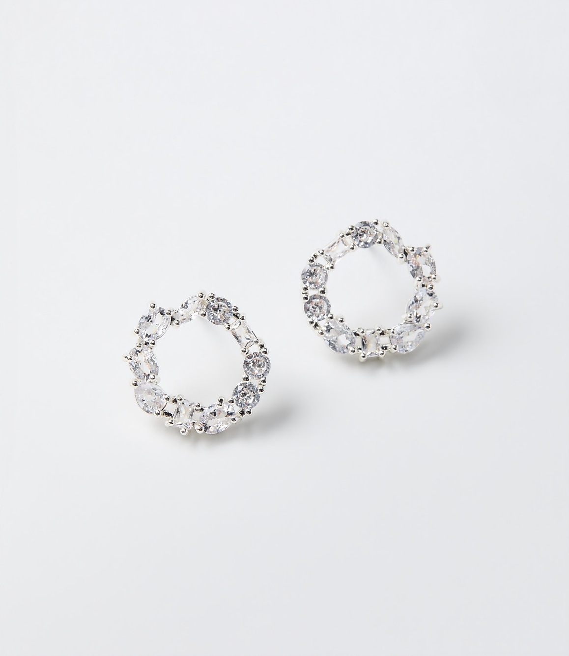 Two circular crystal earrings rest on a plain white background.