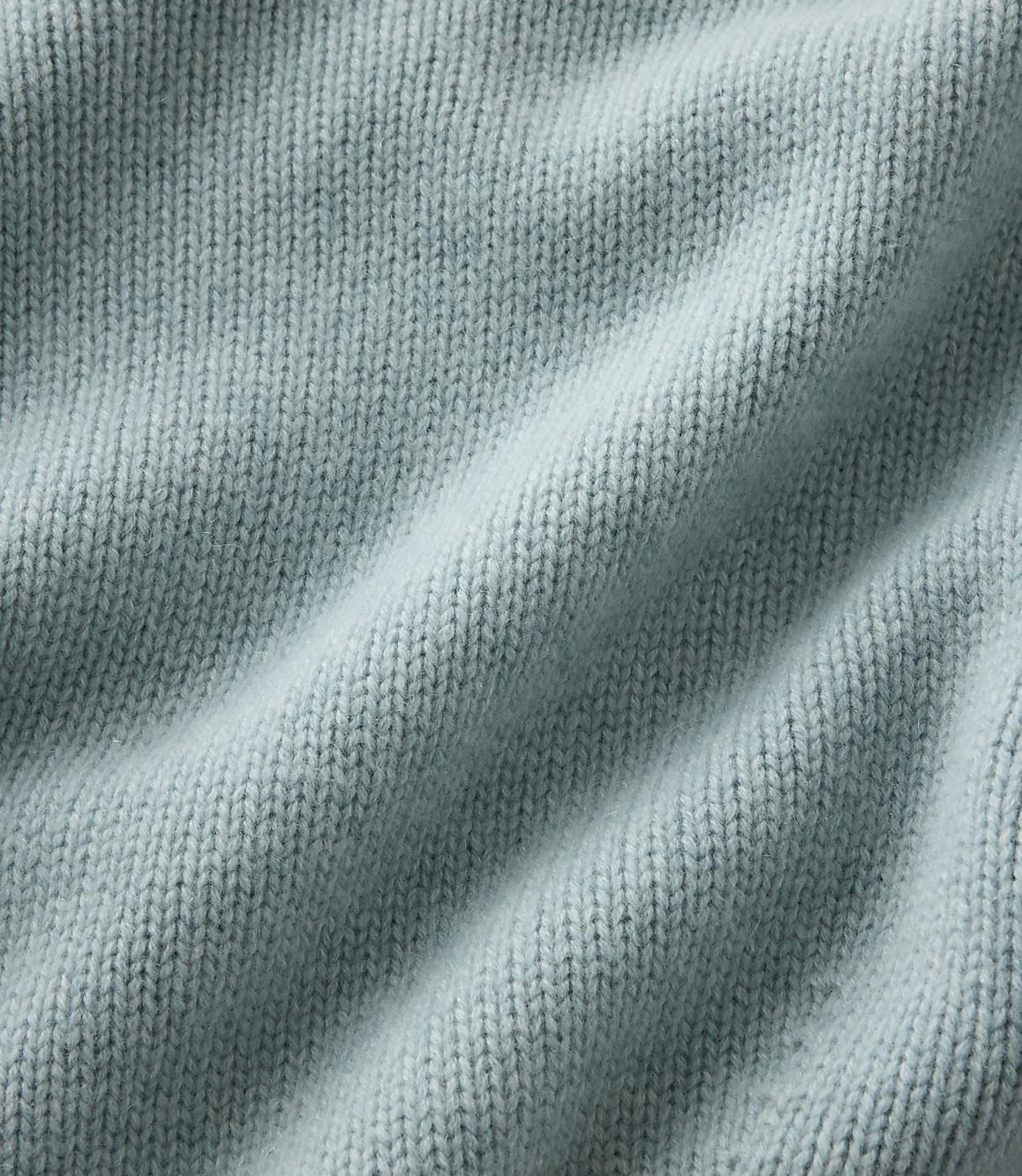 Light blue knitted fabric with soft folds fills the entire foreground and background.