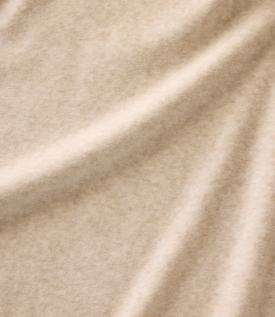 Soft, beige fabric with gentle folds in the foreground and a consistent textured weave throughout the background.