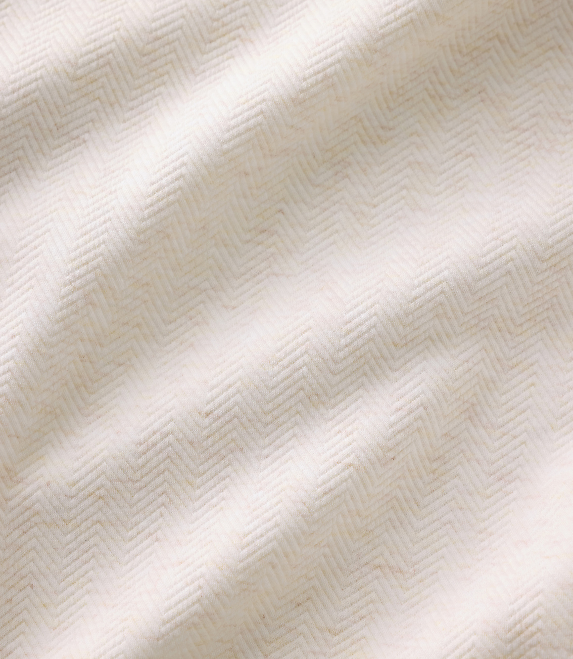White fabric with a textured herringbone pattern folds across the foreground and background.