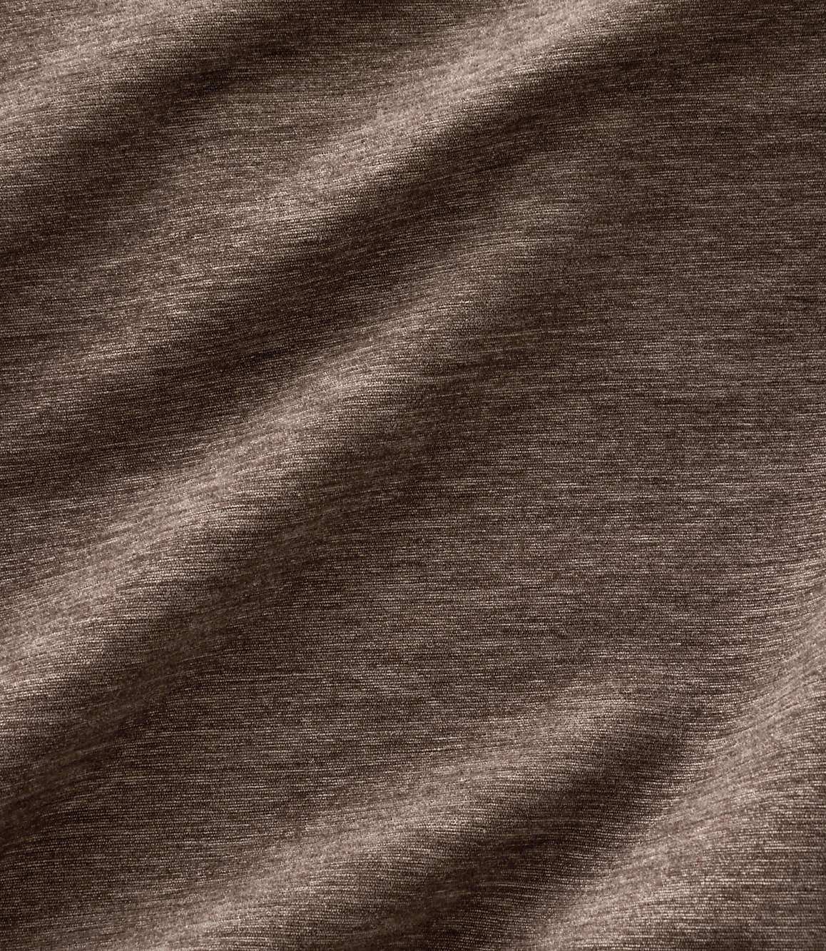 Brown textured fabric with soft folds in the foreground and a consistent woven pattern in the background.