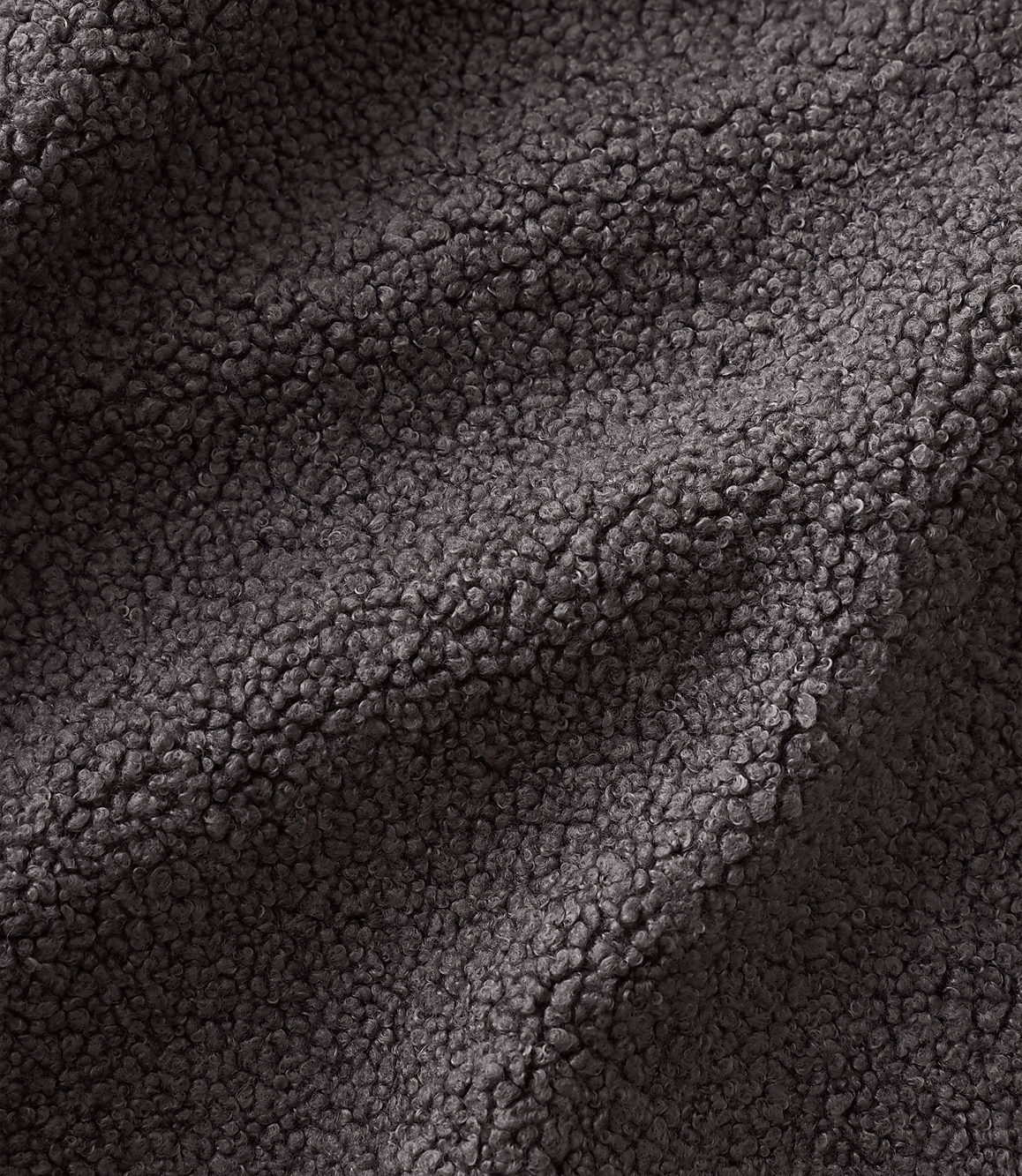 Dark grey, textured sherpa fleece fabric ripples across the foreground and background.