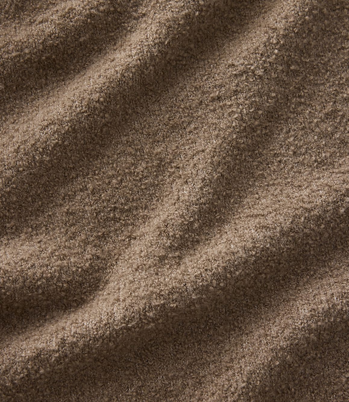 Brown, textured fabric with soft folds in the foreground and a consistent fuzzy pattern throughout the background.