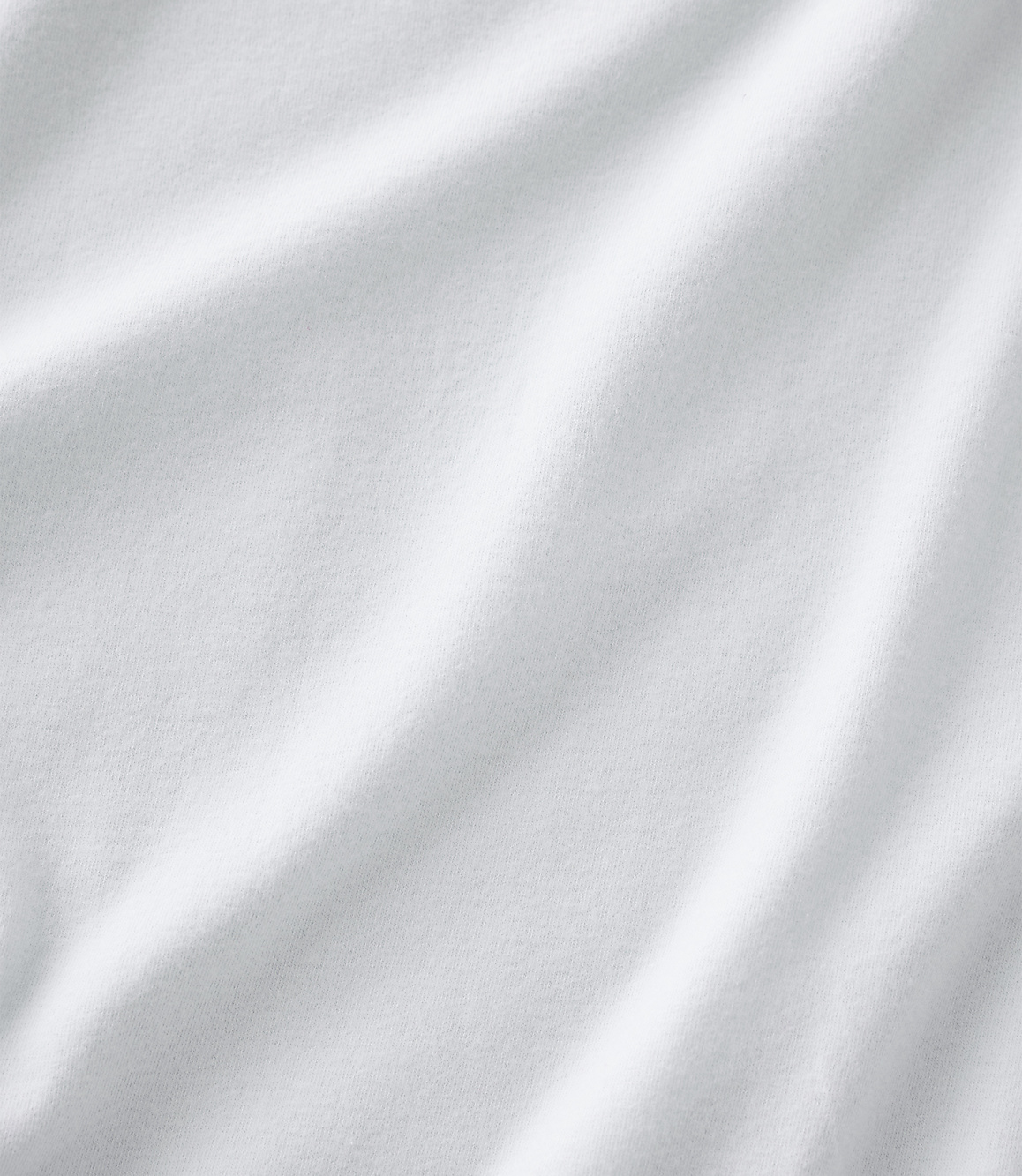 White fabric with soft folds and ripples fills the entire frame from the foreground to the background.