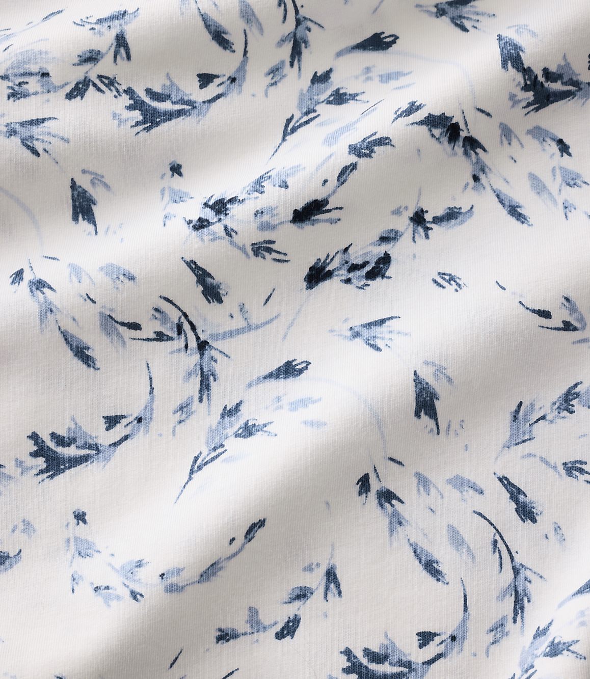 Blue floral patterns are scattered across a white, rippled fabric background.