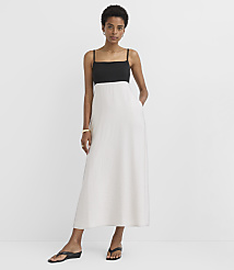 A woman in a black and white maxi dress stands with her hands in her pockets against a plain white background. carousel Product Image 1