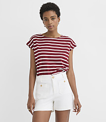A woman in a striped t-shirt and white shorts stands against a plain white background. carousel Product Image 1