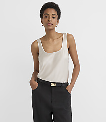 A woman in a cream-colored tank top and black pants stands against a plain white background. carousel Product Image 1