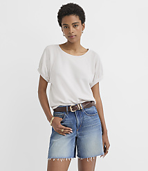 A woman in a light gray t-shirt and denim shorts stands against a plain white background. carousel Product Image 1