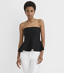 A woman in a black strapless peplum top and white pants stands against a plain white background. carousel Product Image 1