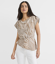 A woman in a tan, leaf-patterned blouse and white pants stands against a plain white background. carousel Product Image 1