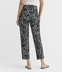 A person stands in the foreground wearing black pants with a white leaf pattern and sandals, against a plain white background. carousel Product Image 3