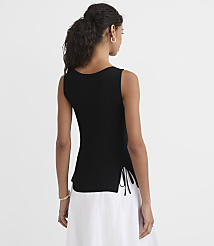 A woman in a black sleeveless top and white skirt stands against a plain white background. carousel Product Image 2
