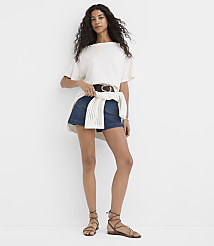 A woman in a white t-shirt, denim shorts, and lace-up sandals stands against a plain white background. carousel Product Image 2