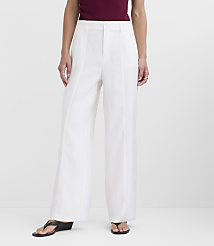 A person stands in white wide-leg pants and black sandals against a plain white background. carousel Product Image 1