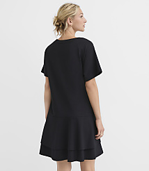 A woman in a black t-shirt dress stands against a plain white background. carousel Product Image 3