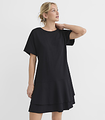 A woman in a black t-shirt dress stands against a plain white background. carousel Product Image 2