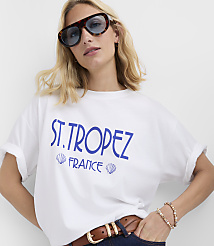 A woman in a white t-shirt with "ST. TROPEZ FRANCE" printed on it poses against a plain white background. carousel Product Image 3
