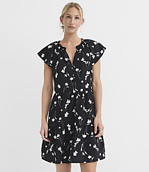 A woman in a black floral dress stands against a plain white background. carousel Product Image 1
