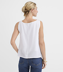A woman in a white sleeveless top and blue jeans stands against a plain white background. carousel Product Image 2