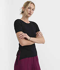 A woman in a black top and burgundy pants stands against a white background. carousel Product Image 1