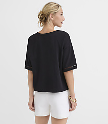A woman in a black top and white shorts stands against a plain white background. carousel Product Image 3