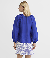 A woman in a blue blouse and patterned skirt stands against a plain white background. carousel Product Image 3