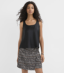 A woman in a black tank top and a patterned skirt stands against a plain white background. carousel Product Image 1