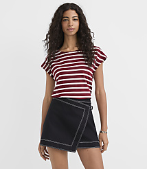 A woman in a striped shirt and a black skort stands against a plain white background. carousel Product Image 1