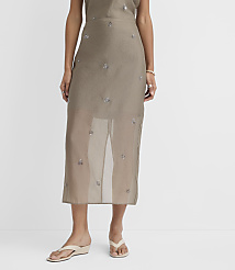 A person stands in a sheer, embellished skirt and cream wedge sandals against a plain white background. carousel Product Image 3