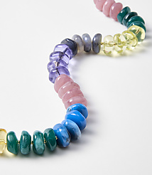 A colorful beaded necklace with smooth, rounded beads in shades of yellow, green, blue, pink, and purple is laid out on a plain white background. carousel Product Image 2
