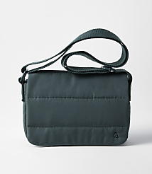 A dark teal quilted crossbody bag with a green strap rests on a plain white background. carousel Product Image 1