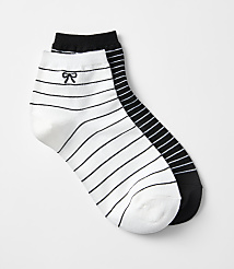 Two striped ankle socks, one white with a black bow and the other black, are laid out against a plain white background. carousel Product Image 1