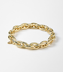A thick, gold chain bracelet lies on a plain white background. carousel Product Image 1