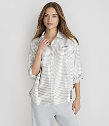 A young woman with long brown hair stands in the foreground wearing a checkered shirt and striped pants, against a plain white background. carousel Product Image 2