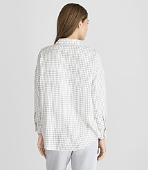 A woman wearing a checkered shirt and striped pants stands against a plain gray background. carousel Product Image 3