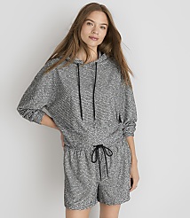 A young woman in a grey patterned hoodie and shorts stands against a plain white background. carousel Product Image 1