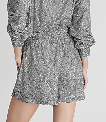 A person wearing a textured grey romper stands against a plain white background. carousel Product Image 3