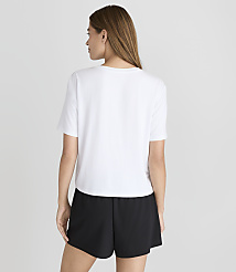 A woman in a white t-shirt and black shorts stands against a plain white background. carousel Product Image 3