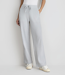 A person stands in light blue, wide-leg, drawstring pants and white sneakers against a plain white background. carousel Product Image 2