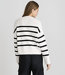 A woman in a white and black striped sweater stands against a plain white background. carousel Product Image 3