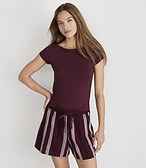 A woman in a maroon t-shirt and striped shorts stands against a plain white background. carousel Product Image 1