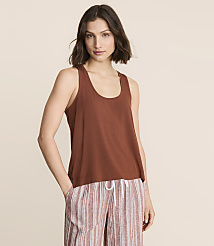 A woman in a brown tank top and striped pants stands against a plain, light brown background. carousel Product Image 1