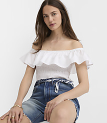A woman in a white off-the-shoulder top and denim shorts poses against a plain white background. carousel Product Image 3