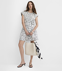 A woman in a floral dress stands with a cream tote bag in front of a plain white background. carousel Product Image 2