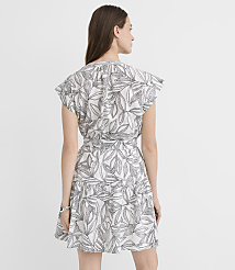 A woman in a white dress with a black leaf print stands against a plain white background. carousel Product Image 3