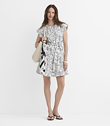 A woman in a white leaf-print dress and black sandals stands against a plain white background, carrying a cream tote bag with a scarf draped over it. carousel Product Image 4