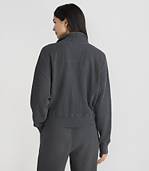 A woman in a dark grey ribbed quarter-zip sweatshirt and matching pants stands against a plain white background. carousel Product Image 3