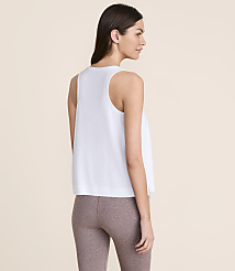 A woman in a white tank top and brown leggings stands against a plain, light-colored background. carousel Product Image 4