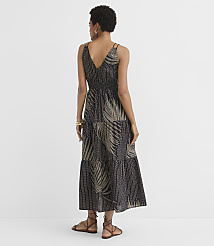A woman in a black and gold palm-print tiered maxi dress stands against a plain white background. carousel Product Image 3